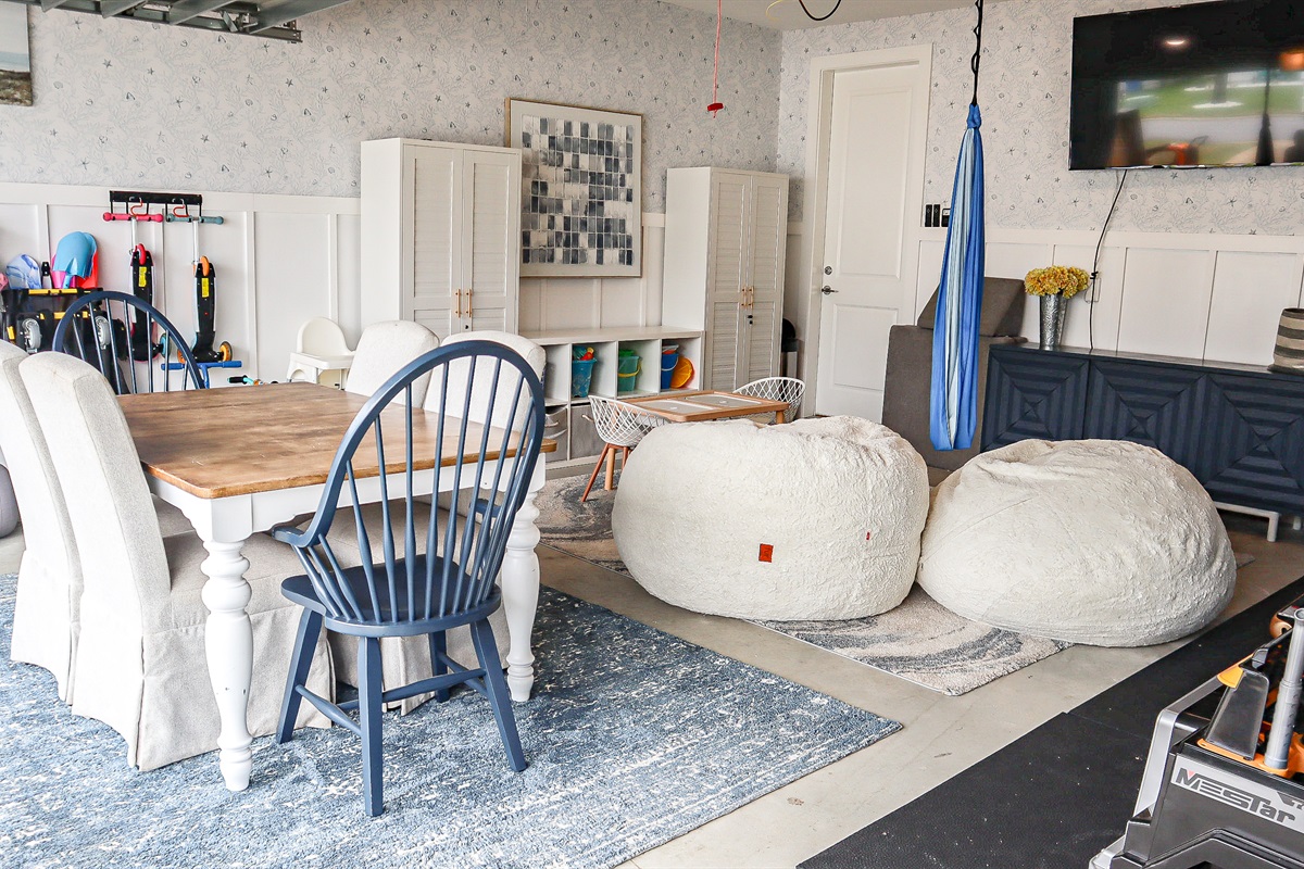 Game/crafting table, bean bags, sensory swing, large TV and kids toys in the garage.