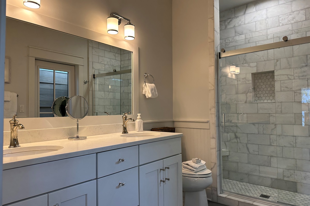 Upstairs king suite bathroom with double vanity, marble shower, and outdoor shower