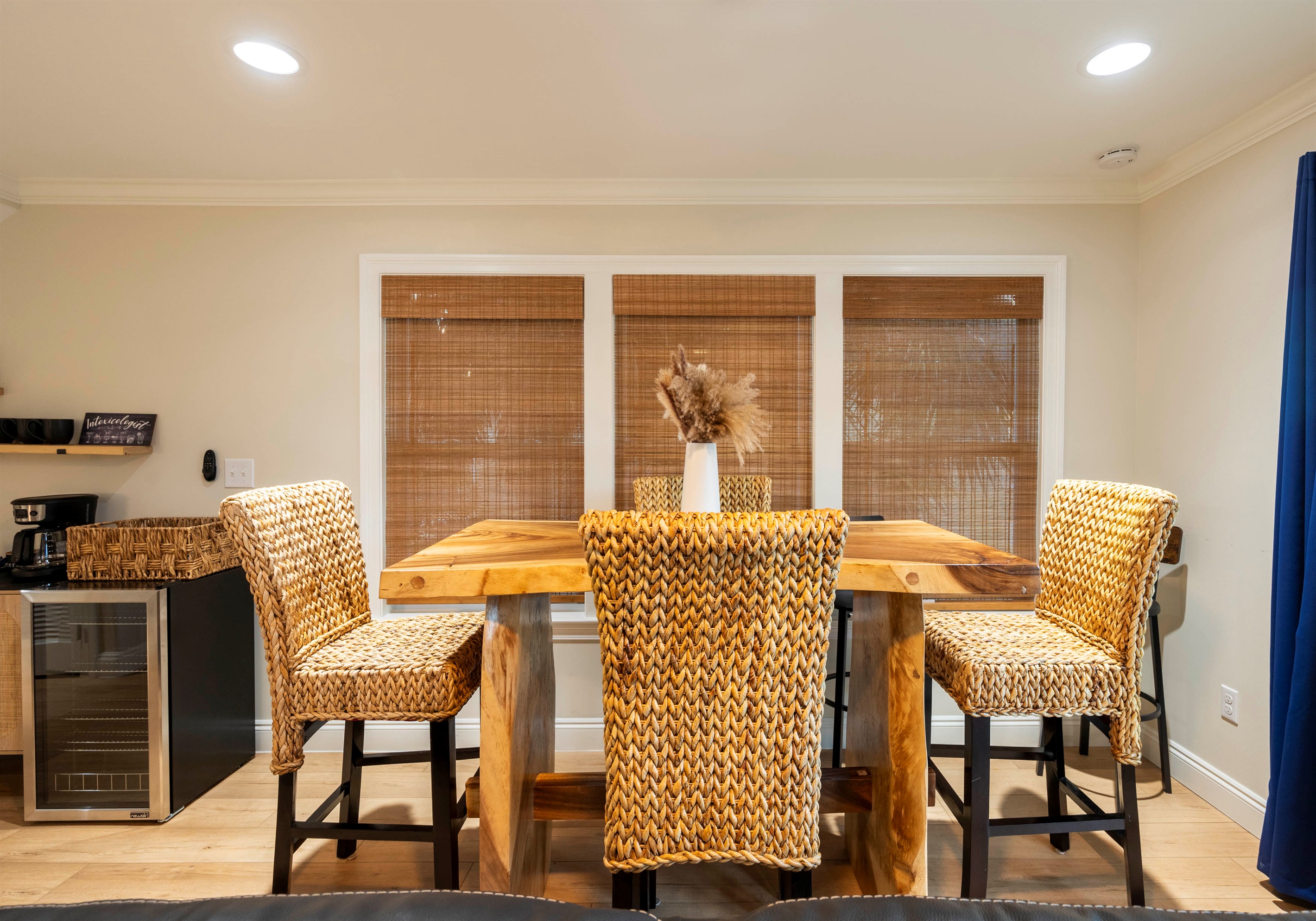 Open dining area with cozy wicker chairs and rustic table for enjoyable meals during your stay at "Bliss on the Bay," by the Laguna Bella in Gulf Shores, AL.