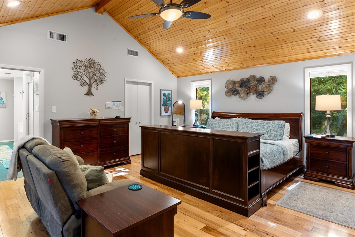 King 1 Bedroom has warm pine floors and ceiling, creating a cozy feel. It includes a door to the backyard, a full-size closet, and all the comforts for a relaxing stay.