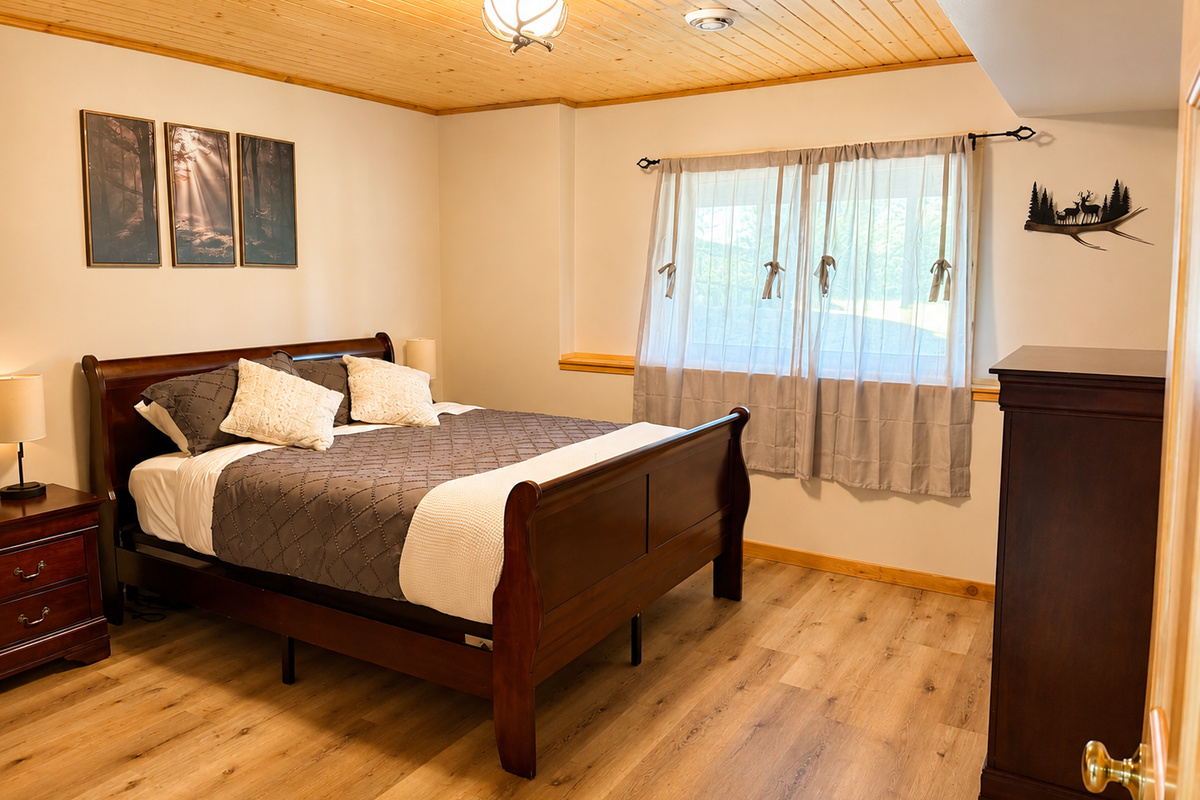 Basement bedroom with warm wood floors and a comfortable bed provides a quiet place to recharge.
