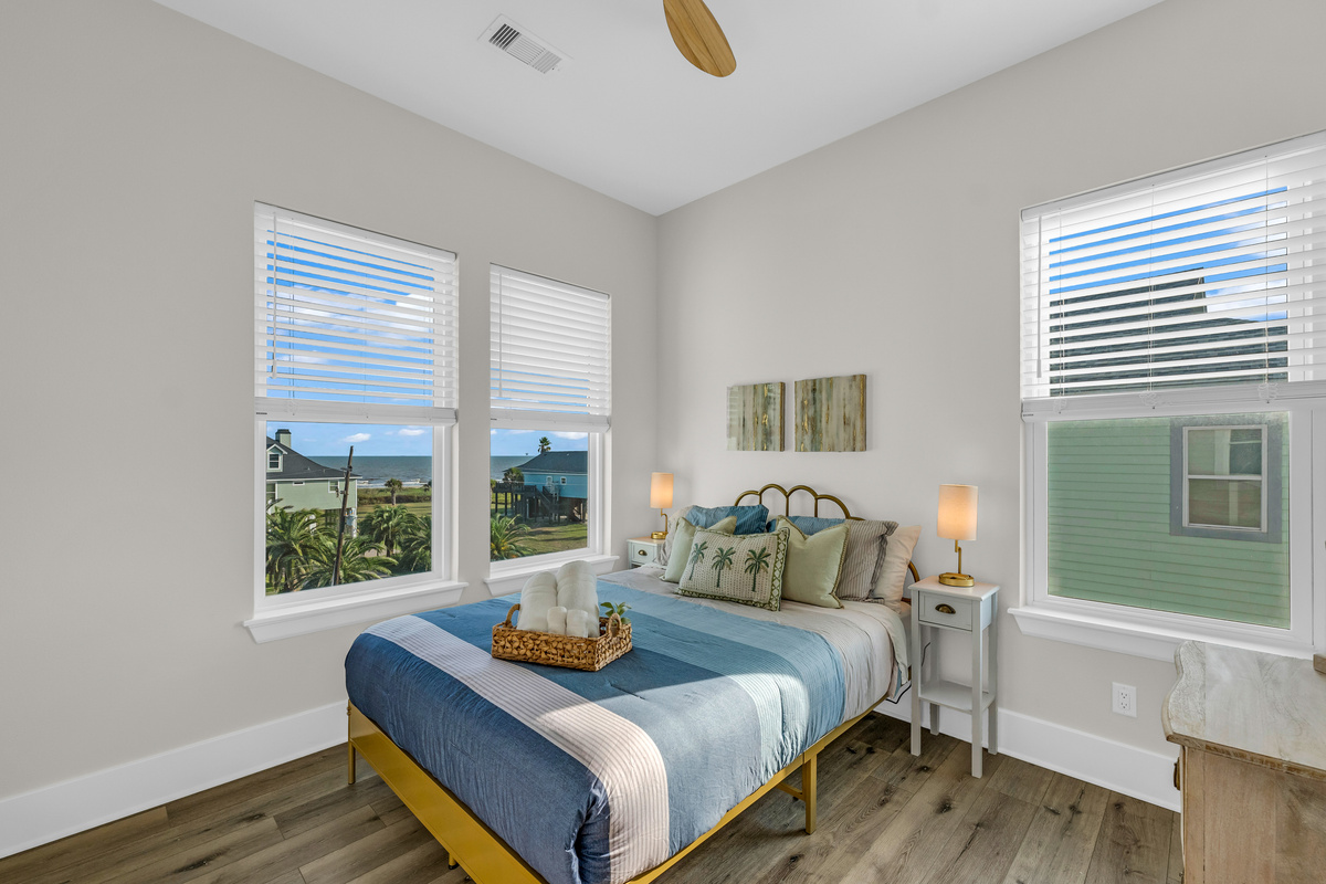 Costa Cristal Bedroom 2: Cozy queen bed with large windows, natural light, and relaxing views. Perfect for a restful night’s sleep.
