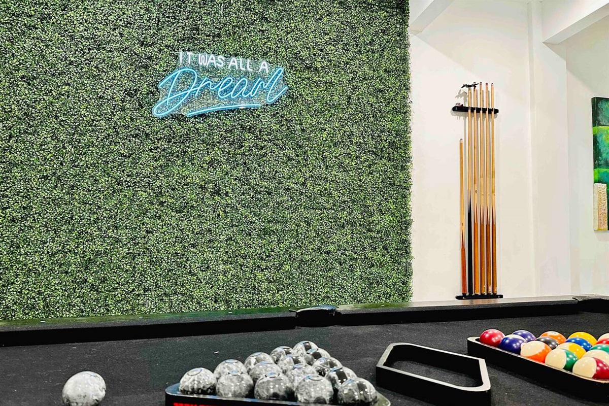 Get lost in the game with this stunning snooker table set against a vibrant green flower wall.