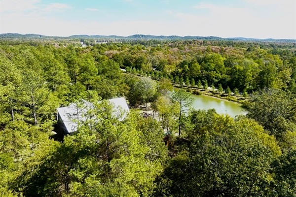 A breathtaking bird’s-eye view of Skippin’ Rocks—6,300+ sq. ft. of pure relaxation surrounded by forest, water, and endless Oklahoma sky.