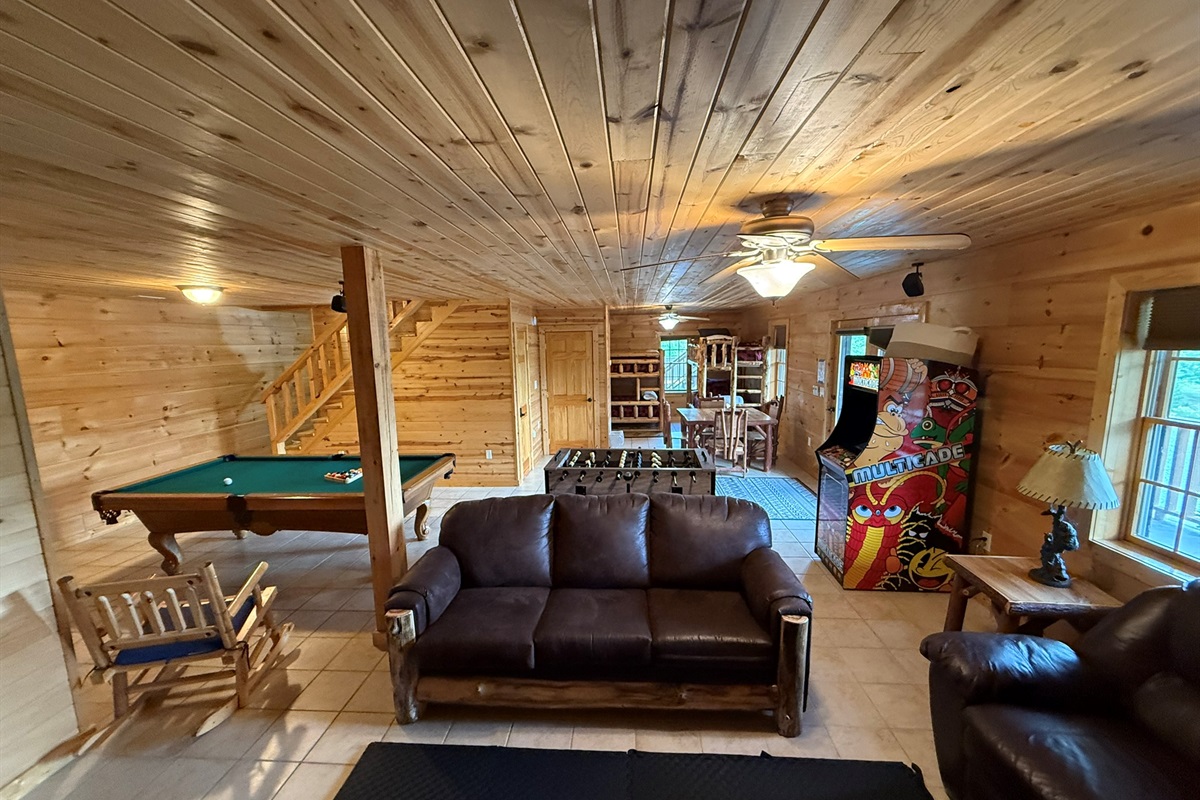 Game room from back where see sofas and bunk beds in back along with Pool table, Foosball, and Arcade Games