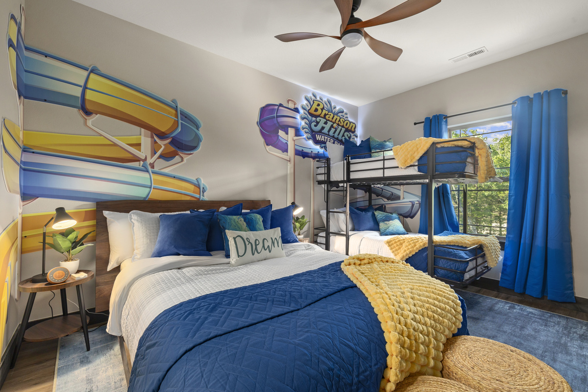 Splash into the Water Park Room, a queen bed plus bunks under waterslide murals.