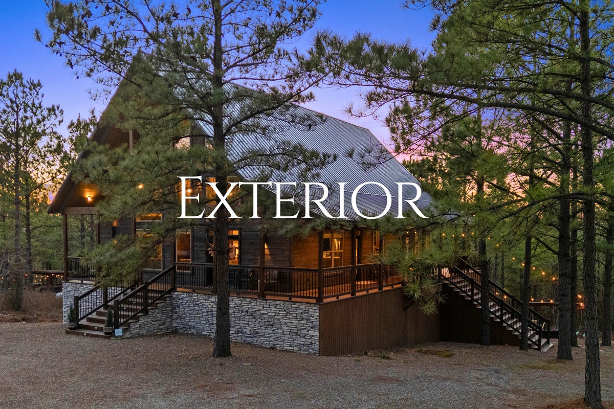 This evening exterior shot shows off the warm, welcoming glow that makes the cabin feel cozy before you even step inside.