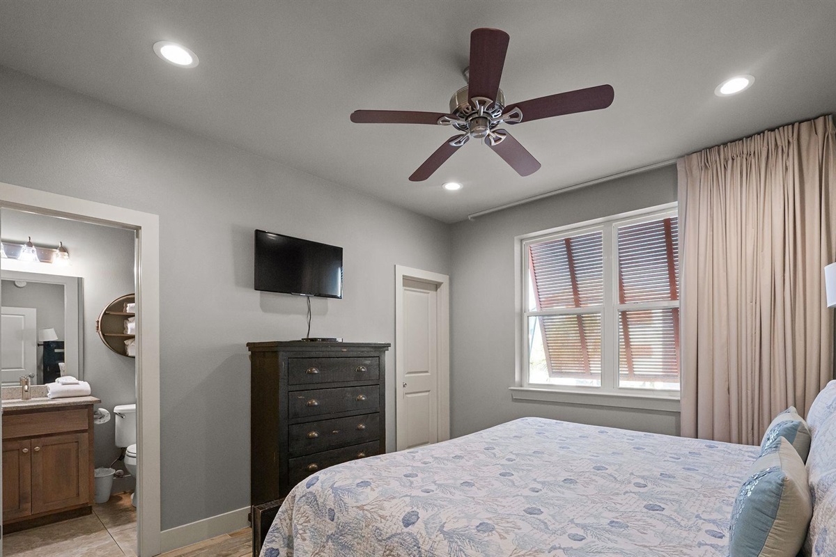Bedroom with king bed, ceiling fan, TV and en-suite bathroom 