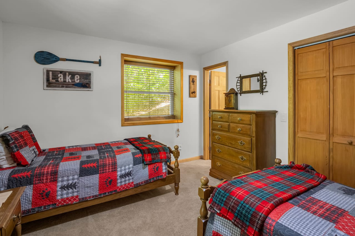 Bedroom in the basement level with two twin-sized beds and a connecting full bathroom 