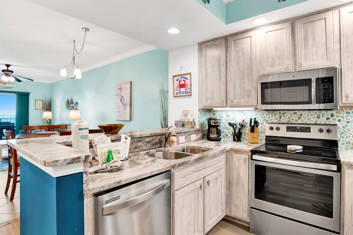 Kitchen with stainless appliances, granite countertops, tiled backsplash and great Gulf view