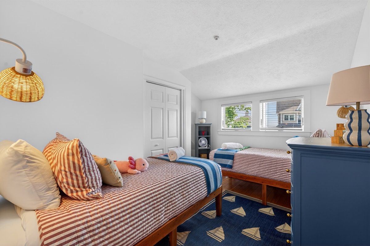 Cheerful twin bedroom with two beds and cozy coastal touches, ideal for kids or extra guests.