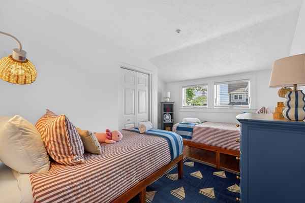 Cheerful twin bedroom with two beds and cozy coastal touches, ideal for kids or extra guests.