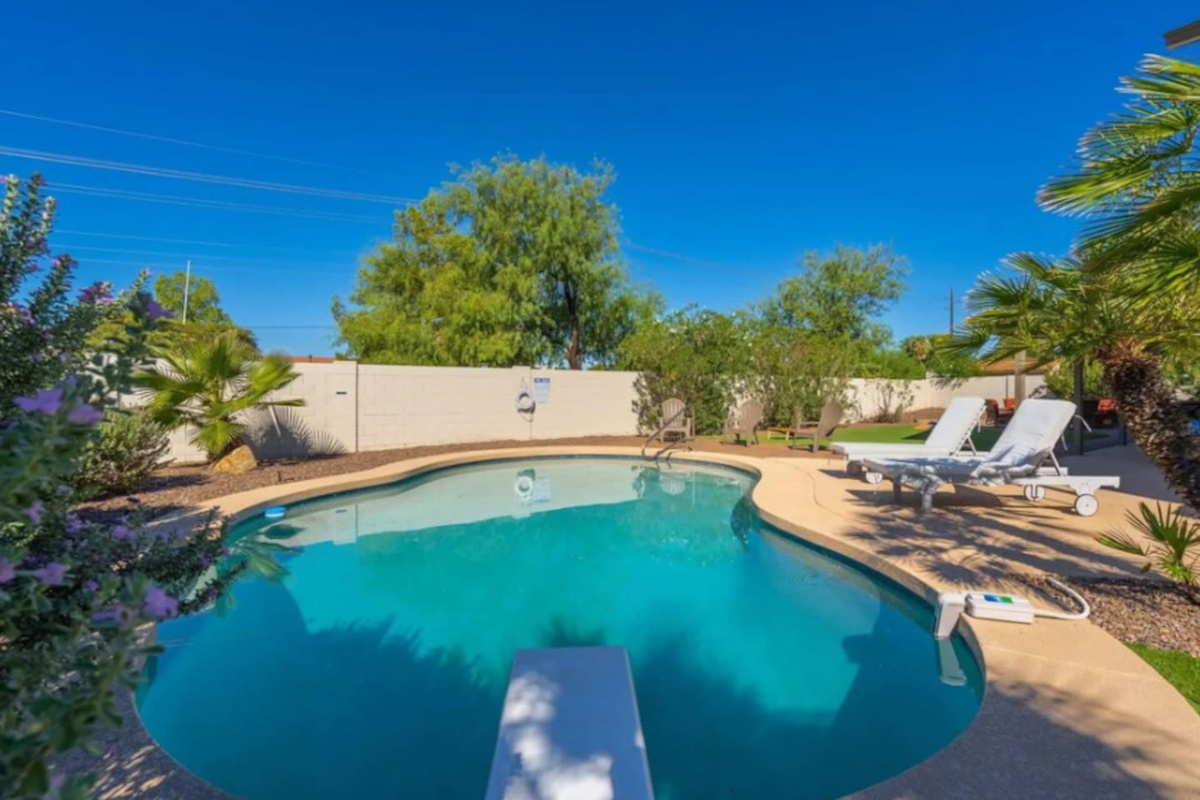 Sparkling pool oasis with mature landscaping, lounge area, and resort-style backyard retreat.