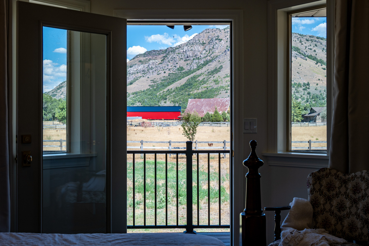 Step directly from the primary bedroom onto a private balcony and take in uninterrupted views of the mountains, open fields, and peaceful landscape.