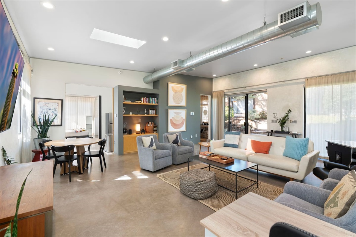 Spacious open living area with comfortable seating, dining space, and modern industrial accents.