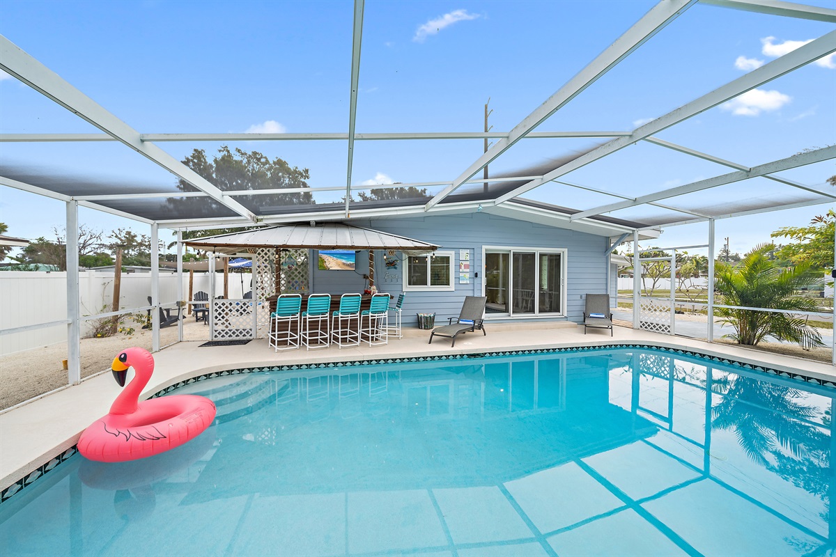 ☀️ Enjoy resort-style living with pool, tiki bar with TV, sun loungers, and a screened lanai.