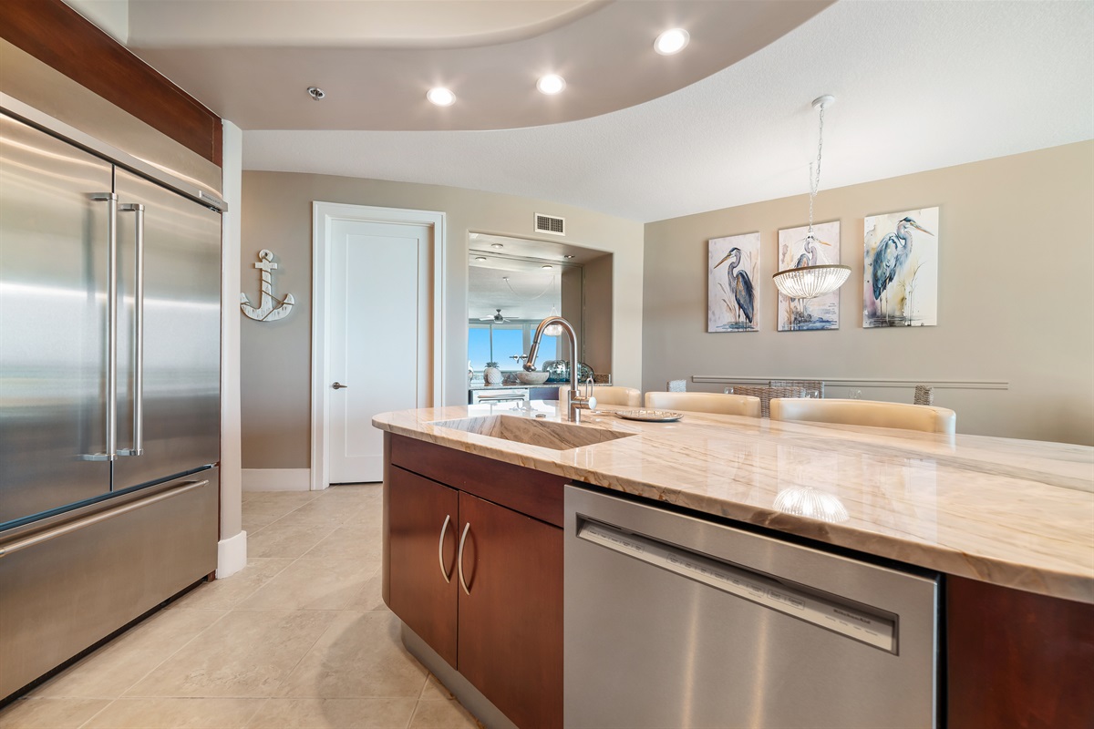 Gourmet kitchen with stainless steel appliances, granite countertops, and island seating. Open floor plan seamlessly connects to the living and dining areas.