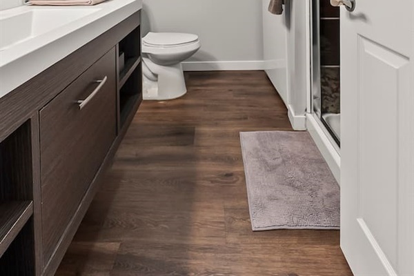 Spacious bathroom with sleek flooring, walk-in shower, and convenient in-unit laundry.