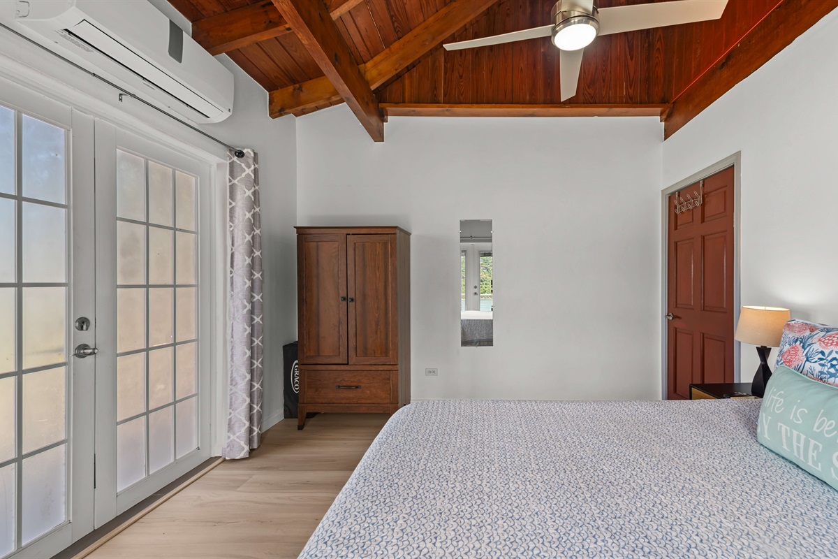 Spacious bedroom with lots of natural light, a ceiling fan, air conditioning, and vaulted ceilings