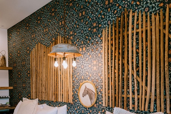 The Corral Suite's custom feature wall, designed floor to ceiling &mdash; layered texture, pattern, and modern Western character.