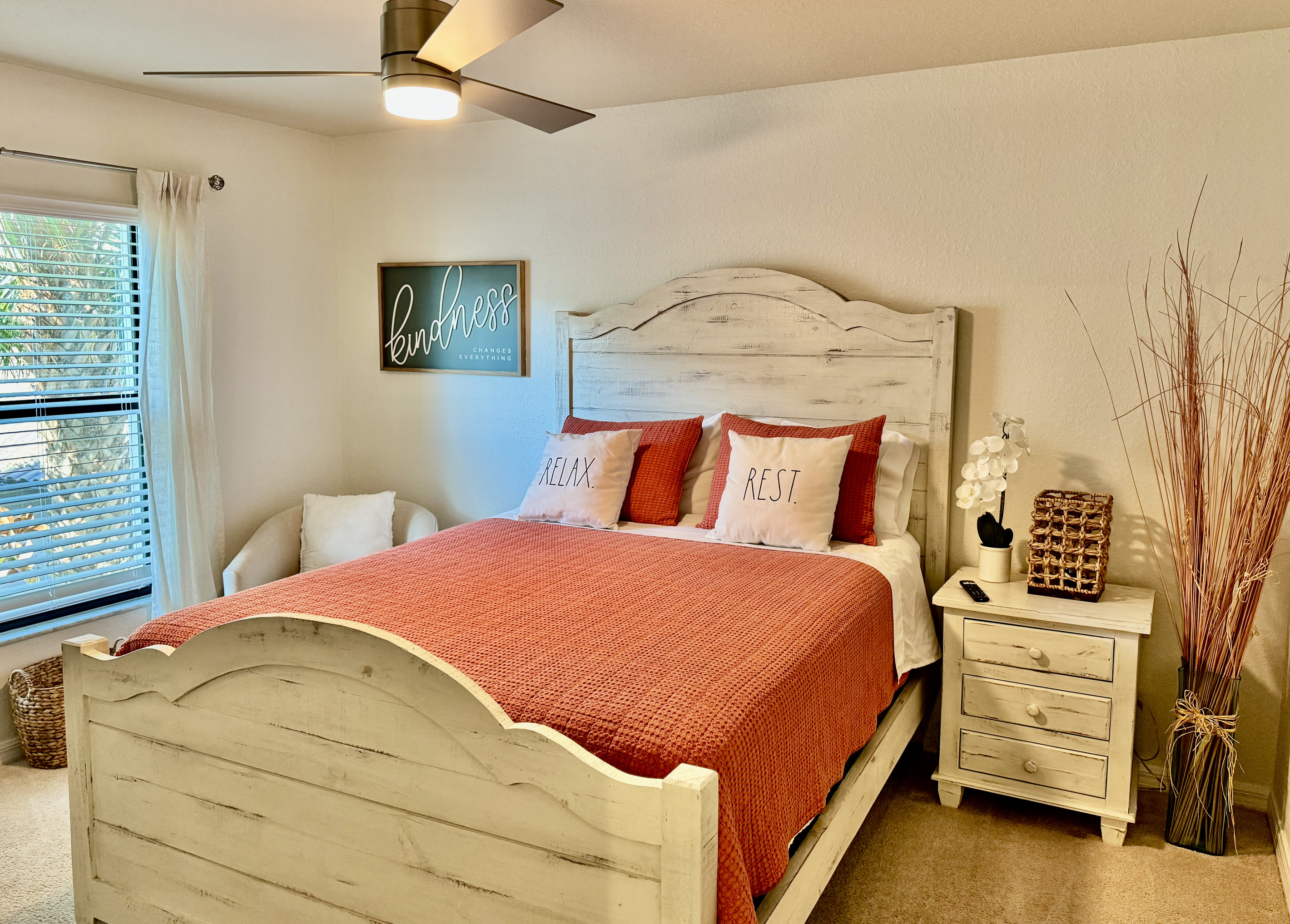 Second bedroom—queen bed, TV, accent chair.