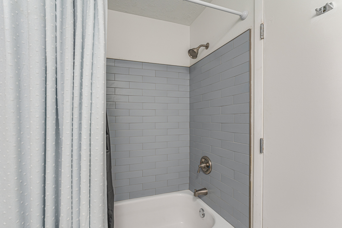 Connected to the primary bedroom, the ensuite bathroom features a bathtub, fresh towels, and all the essentials for a comfortable stay.
