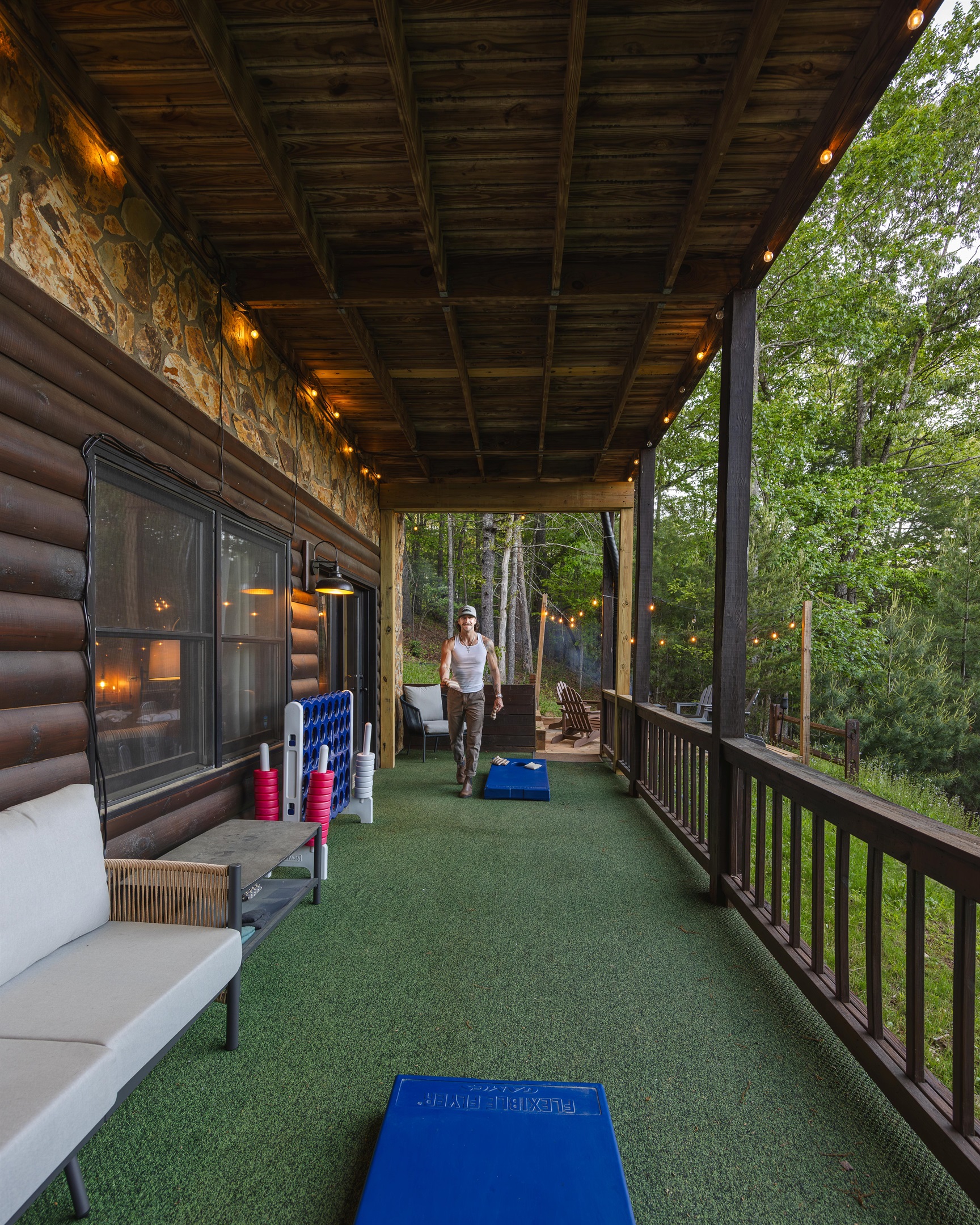 Challenge friends or family to a game of cornhole on the lower deck, surrounded by forest views, with plenty of seating nearby for relaxing between rounds.