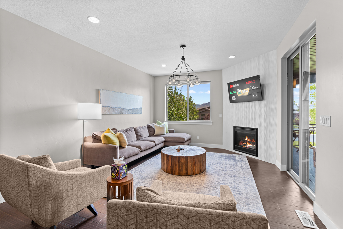 The living room has mountain views, a fireplace, TV, and access to the outdoor patio.