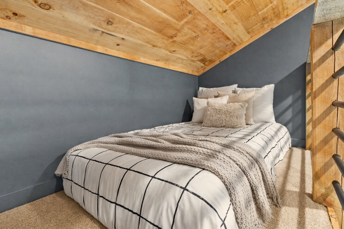 A tucked-away twin bed in the loft, ideal for a cozy night&rsquo;s rest in a peaceful setting.