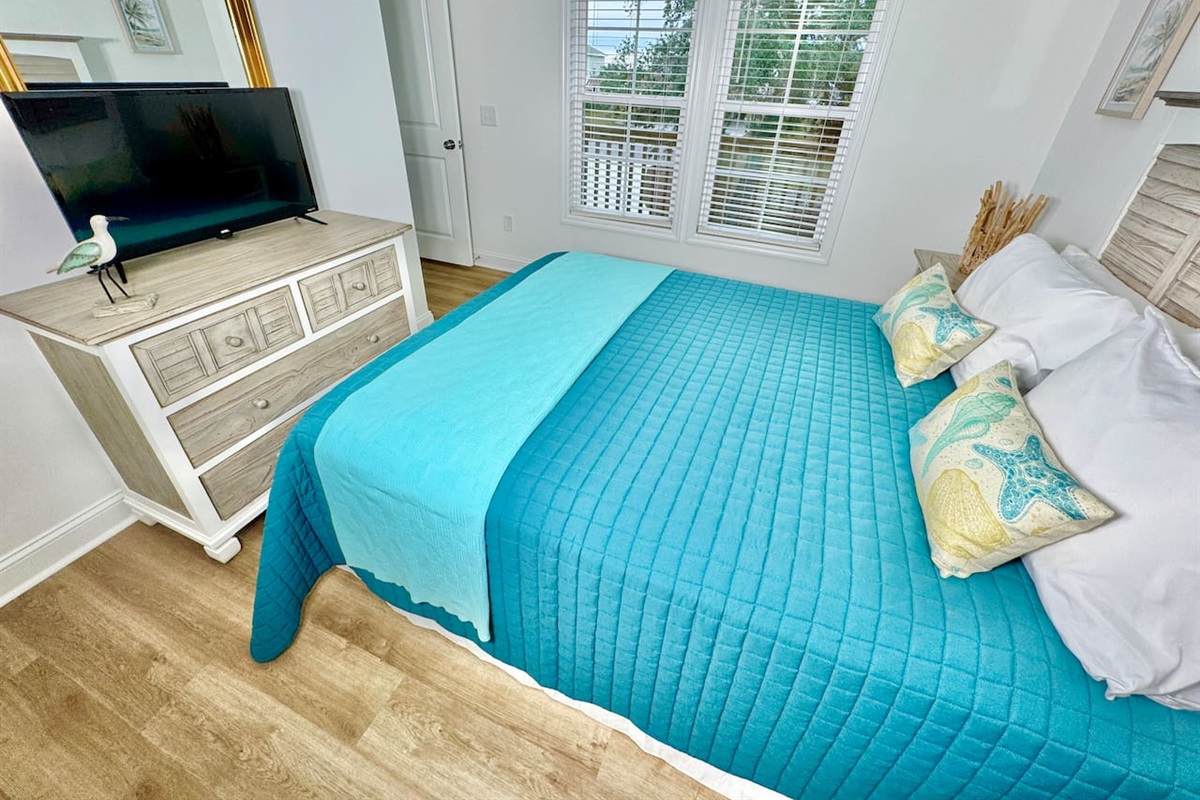 Queen bed with a smart TV and blackout curtains.