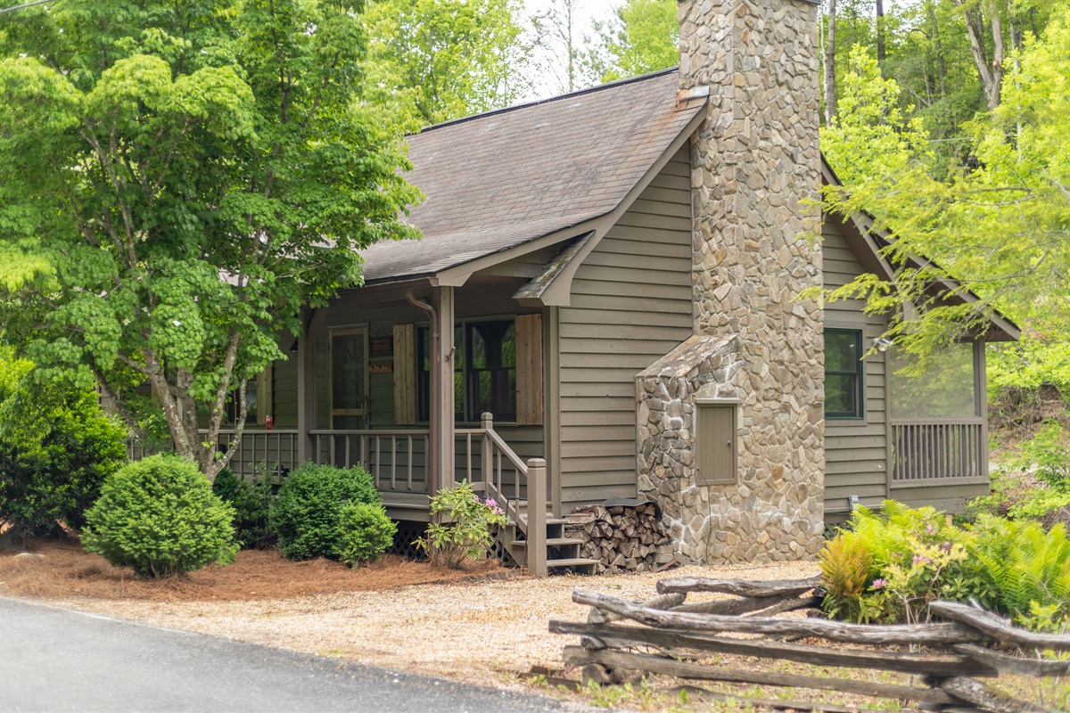 A side view of the cabin highlights Bear’s Den’s peaceful wooded setting alongside beautiful Snowbird Creek.