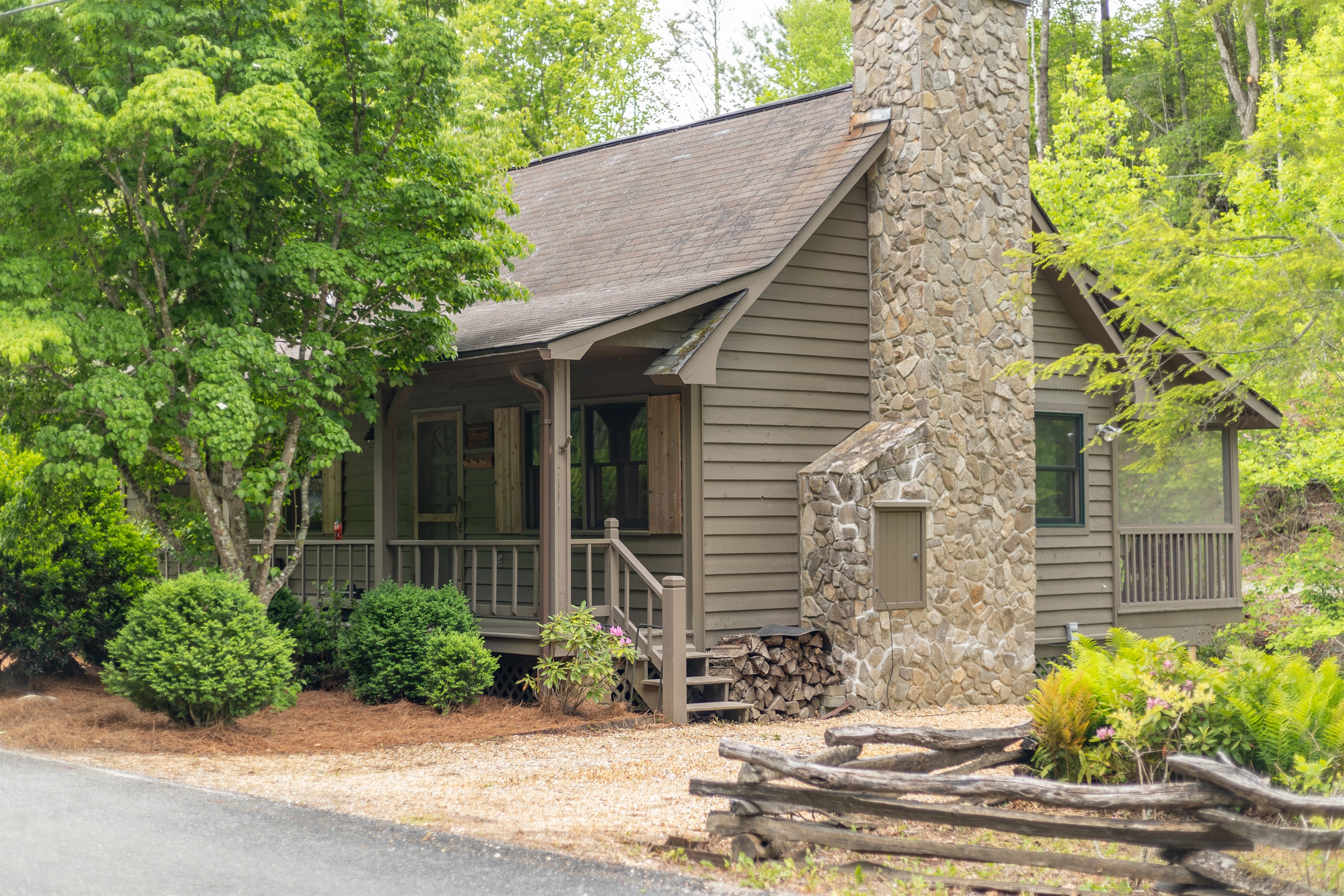 A side view of the cabin highlights Bear’s Den’s peaceful wooded setting alongside beautiful Snowbird Creek.