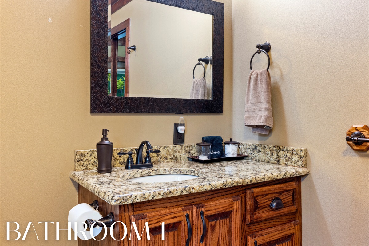 Bathroom 1 with granite counters and plenty of cabin character.