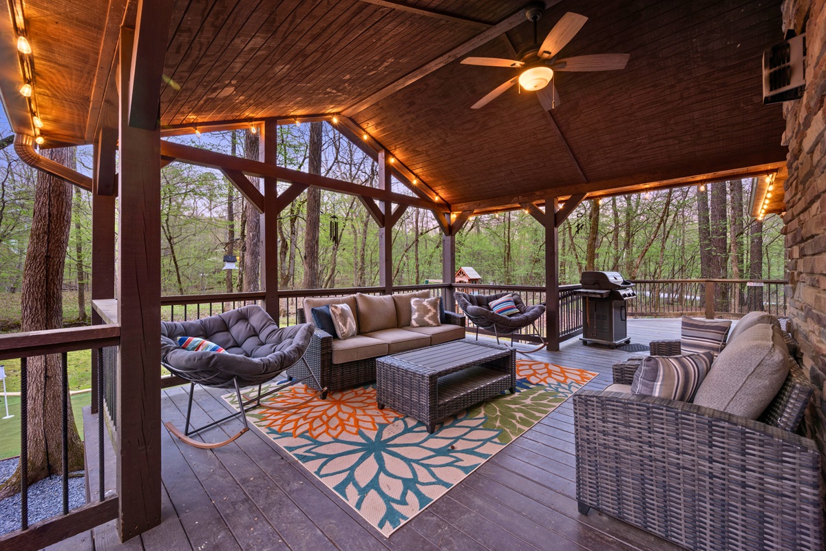 The covered patio creates a comfortable outdoor living space where you can sit back and take in the surrounding woods.
