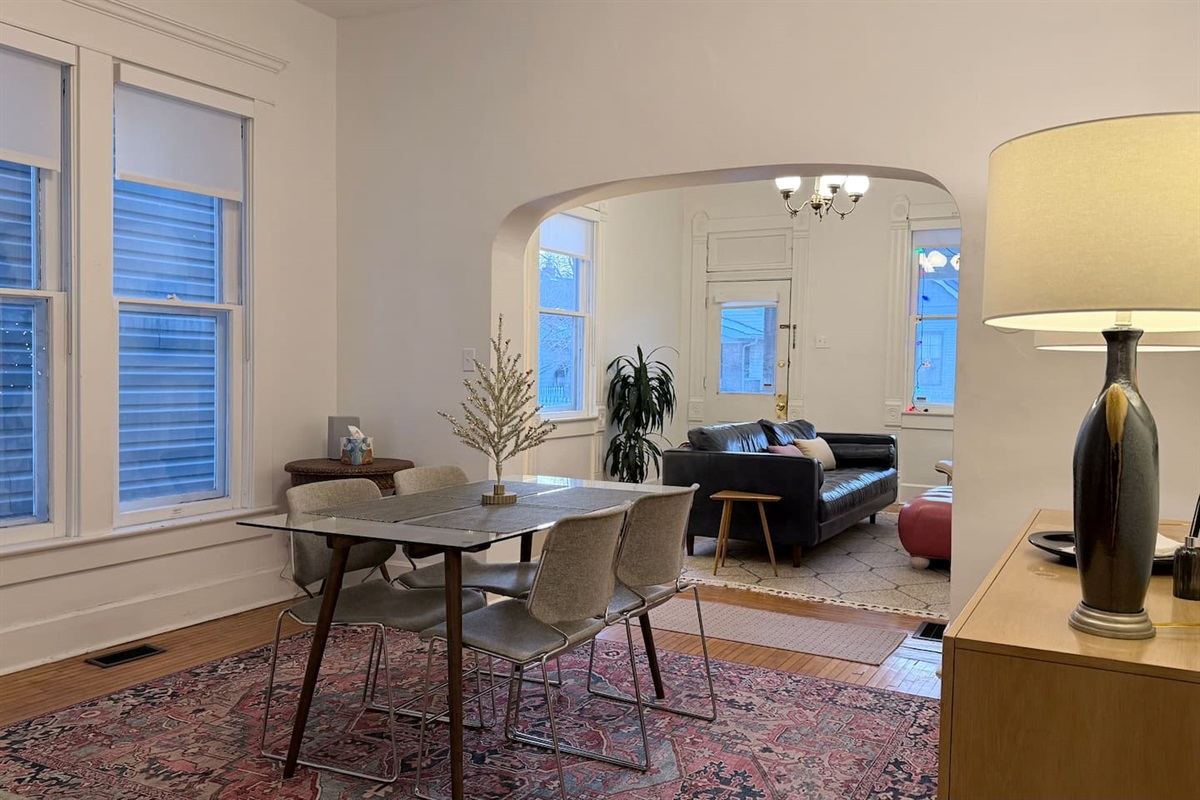 Natural light pours through tall windows, while classic arches create a beautiful sense of flow between the dining area and adjoining living spaces.