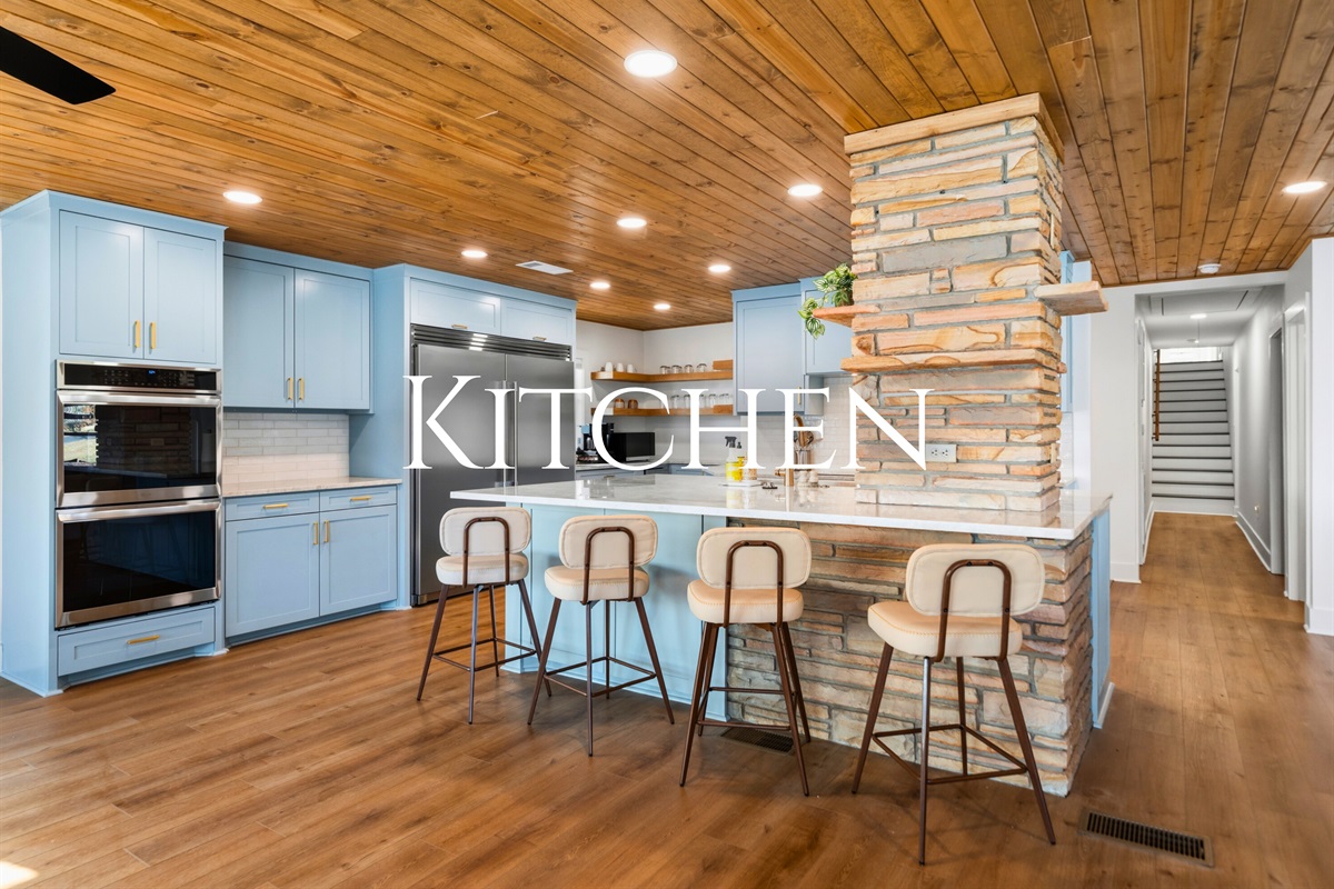 The kitchen features a long breakfast bar with seating, making it a great place for casual meals, morning coffee, or chatting with the cook while dinner comes together.