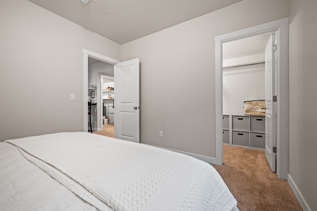 Rest easy in this cozy queen bedroom, complete with plush bedding and a generous walk-in closet for all your belongings.