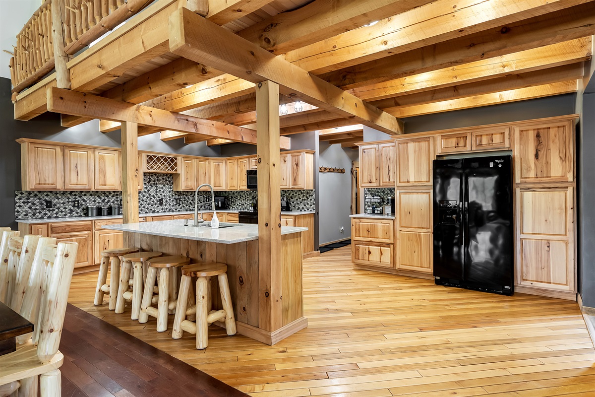 Huge Kitchen with island, dishwasher, stove, refrigerator, microwave, air fryer, cooking utensils and Keurig.