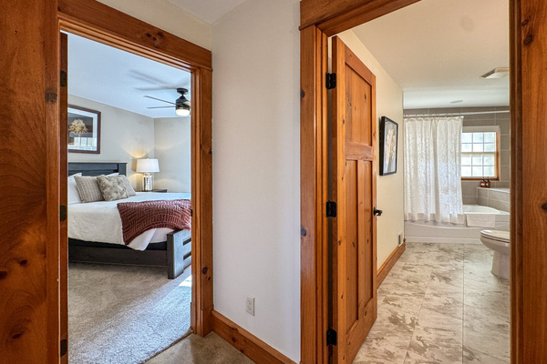 Hallway view of a bedroom and adjacent bathroom.