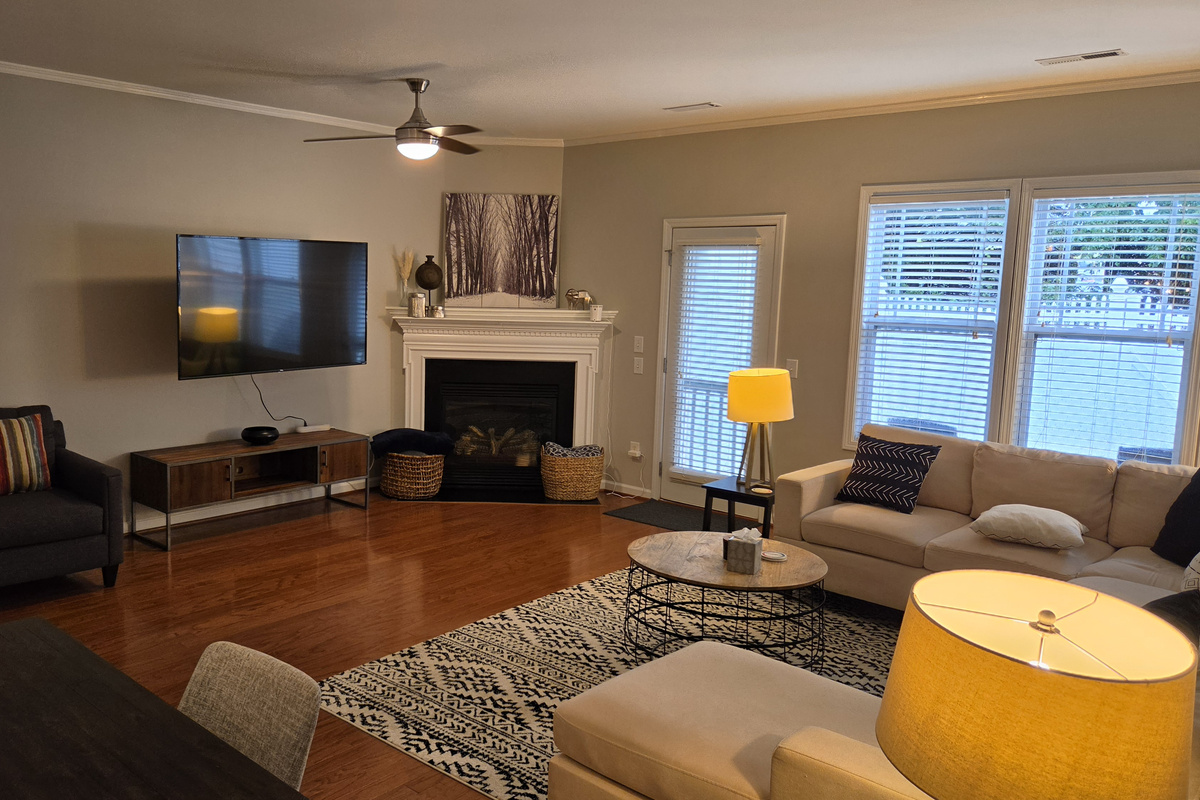 Living room with fireplace, backyard access, dining area