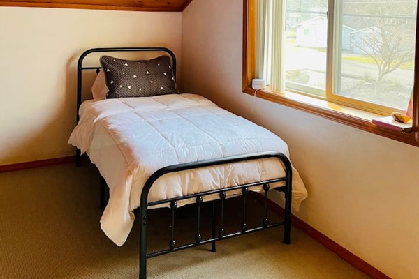 Quiet bedroom with large window and peaceful lake house atmosphere.
