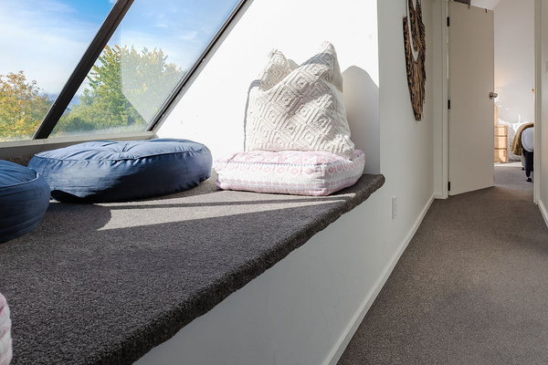 Fernhill Mountain Escape’s upstairs sunbed adds a quiet Queenstown nook, with alpine light through the angled window above Fernhill.