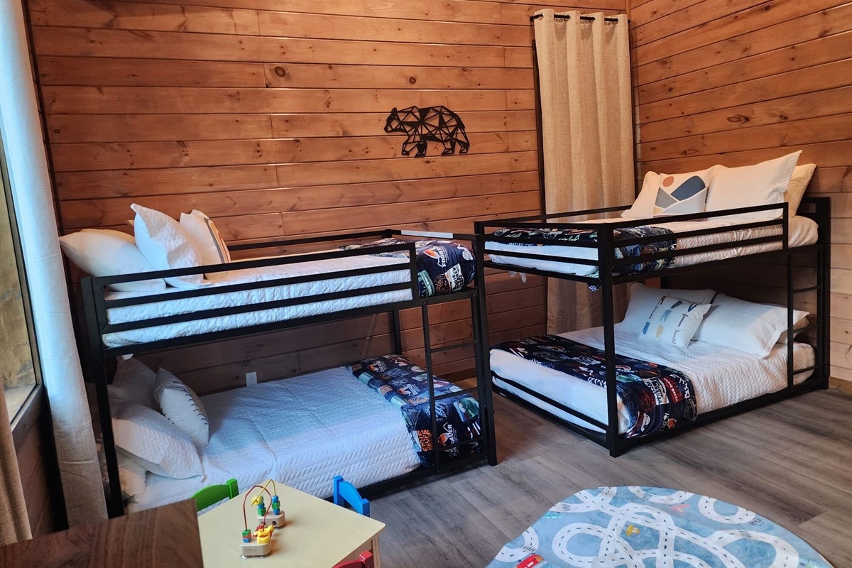 Family-friendly kids’ room with bunk beds, toy table, and cheerful vibes.