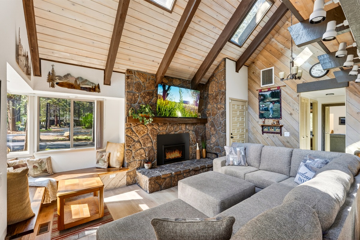 A lively, inviting living room designed for gathering and unwinding—ample seating for everyone, a cozy fireplace, Smart TV for entertainment, and year-round comfort with central heat and AC.