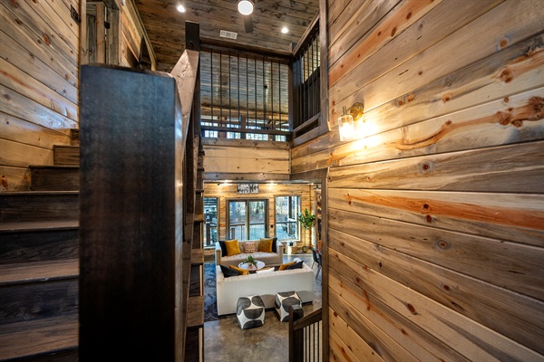 A stunning open view connects the staircase, upstairs loft, and inviting living room below.