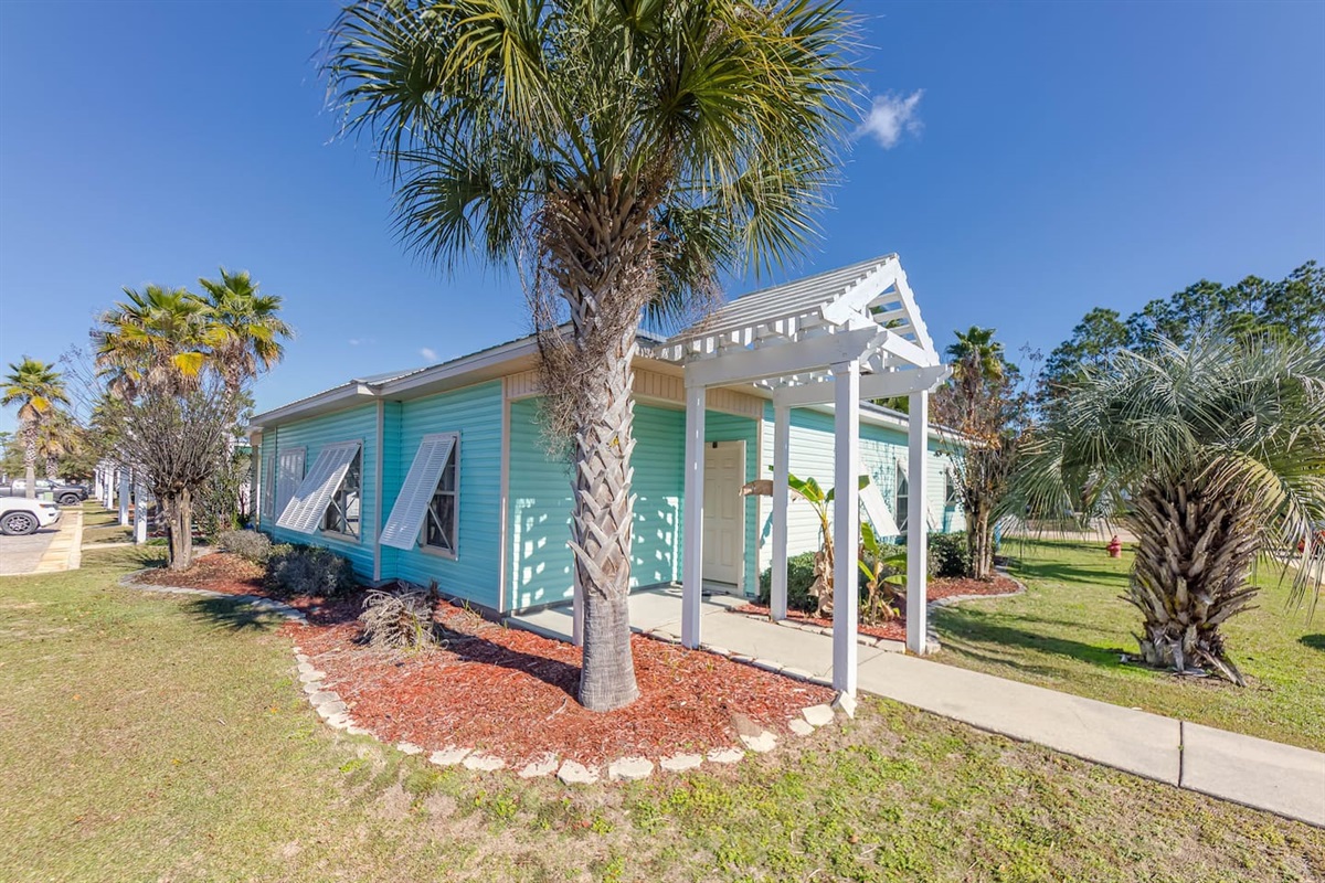 Exterior View: Vibrant beach house surrounded by swaying palms and colorful landscaping!