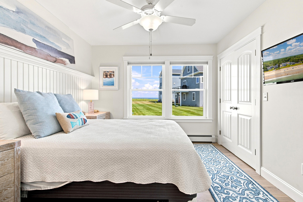 A bright, inviting bedroom with ocean views and plenty of natural light for relaxing vacation mornings.