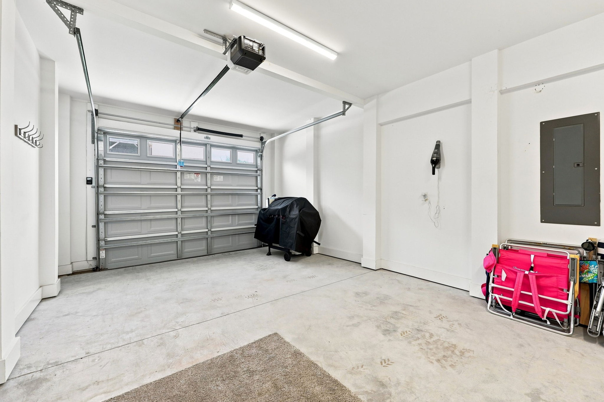 Spacious garage with ample storage space, beach gear, and convenient access to the home