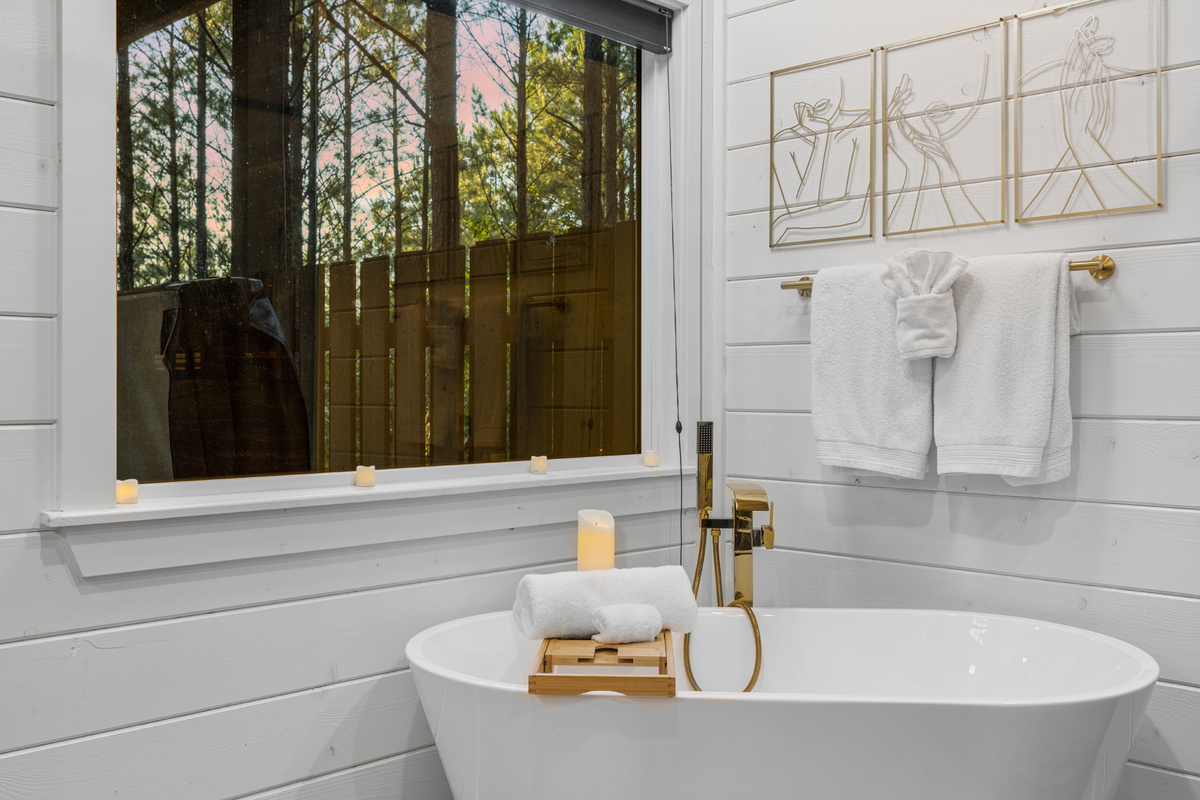 A full bathroom with a deep soaking tub and bathtub tray, perfect for long, relaxing baths and slow unwinding.