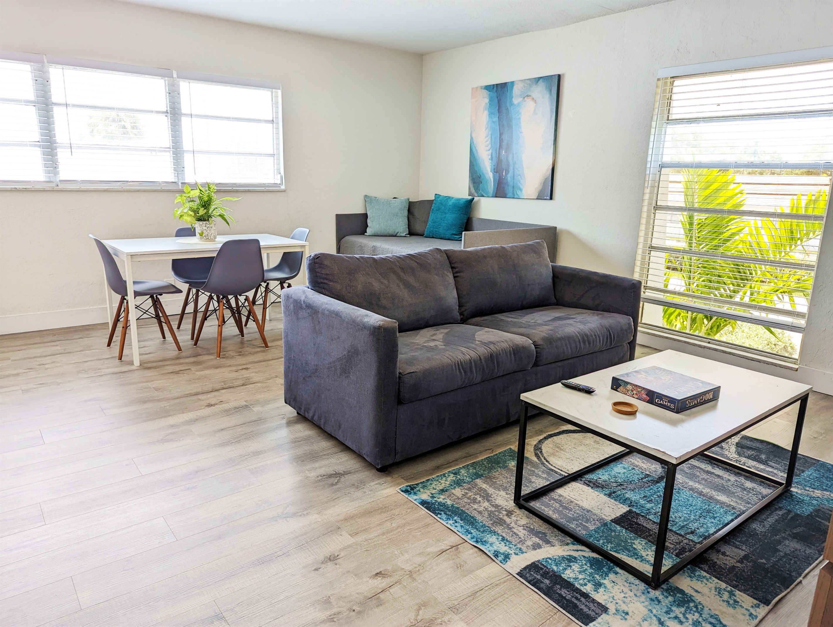 Showing large windows with queen pull out bed sofa. Day bed for 3rd guest is located in the corner of the living room.